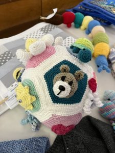 Crocheted ball made from pentagons. Each pentagon has a different crocheted element